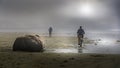 Bikers in Dense Fog biking on the Beach in Cox Bay at the Pacific Rim National Park Royalty Free Stock Photo