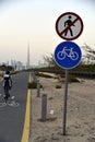 Bikers at Dubai skyline from Nad Al Sheba bicycle track road, Dubai, United Arab Emirates