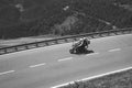 Bikers in mountain road in action ride, traveling across Europe, motorcycle tour, curve highway in mountains, copy space, extreme