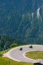 Bikers in mountain road in action ride, traveling across Europe, motorcycle tour, curve highway in mountains, copy space, extreme