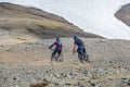 Bikers riding mountain bikes in the Laugavegur multiday trail in Icelandic Landmannalaugar mountains, Iceland, snow, summer time
