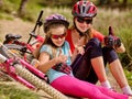 Bikes cycling family. Mother and daughter sitting road near bicycles. Royalty Free Stock Photo