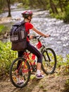 Bikes cycling girl with big rucksack cycling fording throught water . Royalty Free Stock Photo