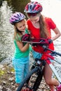 Bikes cycling girl. Children rides bicycle. Bicyclist watch tablet computer.