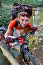 Bikes cycling girl cycling fording throught water on log .