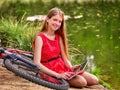 Bikes cycling girl. Girl wearing red polka dots dress recreation near bicycle into park. Royalty Free Stock Photo