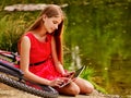 Bikes cycling girl into park. Children watch tablet pc. Royalty Free Stock Photo