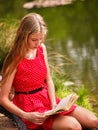 Bikes cycling girl into park. Girl read book leaning on bicycle on shore. Royalty Free Stock Photo