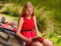 Bikes cycling girl into park read book bicycle on shore. Royalty Free Stock Photo