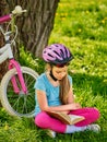 Bikes cycling girl wearing helmet reads book. Royalty Free Stock Photo