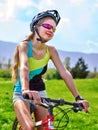 Bikes cycling girl wearing helmet rides bicycle aganist blue sky. Royalty Free Stock Photo