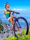 Bikes cycling girl wearing helmet rides bicycle aganist blue sky. Royalty Free Stock Photo