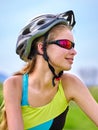 Bikes cycling girl wearing helmet rides bicycle aganist blue sky. Royalty Free Stock Photo