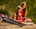 Bikes cycling kids. Girl recreation near bicycle into park. Royalty Free Stock Photo