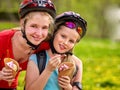 Bikes girls cycling eating ice cream cone in park. Royalty Free Stock Photo