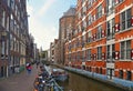 Bikes over canal Amsterdam city. Picturesque town landscape with people and old buildings facade in Netherlands with vi