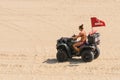 Bikini-clad Lifeguard drives a dune buggy at Virginia Beach, VA.