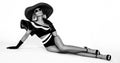 Bikini fashion. Elegant tanned woman in a black and white bikini and in big hat isolated on white background in studio.  Swimsuit Royalty Free Stock Photo