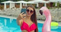 Bikini girl making photos on beach Summer, girl take selfie at pool. Beautiful young woman in summer wih smartphone Royalty Free Stock Photo