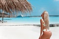 Bikini Model enjoying on tropical beach. Pretty slim girl posing on exotic island in turquoise ocean. Blonde in trendy swimwear Royalty Free Stock Photo