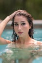 Bikini model posing in a pool with hand on head Royalty Free Stock Photo