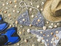 Bikini set, swim fins and straw hat on beach sand Royalty Free Stock Photo