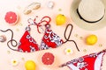 Bikini swimsuit with straw hat, flowers and fruits, flat design, summer concept. Beach destination, summer fashion Royalty Free Stock Photo