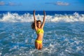 Bikini girl jumping in Caribbean sunset beach