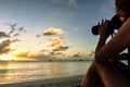 Bikini woman taking pictures of  beach sunset on the ocean. Royalty Free Stock Photo