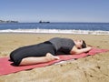 Bikram yoga supta bajrasana pose at beach