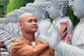 biksu membersihkan patung Buddha bersih pada Hari Waisak