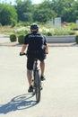 Policeman patrolling park on bicycle in new summer uniform.
