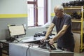 Bila Tserkva, Ukraine, March 2021: Gray-haired worker testing audio speaker at factory