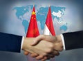 Two people shaking hands in front of Indonesia and China flags Royalty Free Stock Photo