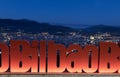 Bilbao sign with the city at dawn behind.