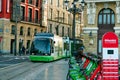 BILBAO, SPAIN-DECEMBER 19, 2021 : Euskotren city tram runs on tramway track on public urban street. People at bike station of