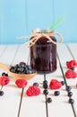 Bilberries in wood spoon. Crimson raspberry and Royalty Free Stock Photo