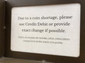 Bilingual sign. Due to a coin shortage, please use credit or debit card or provide the exact