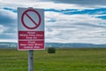 A bilingual sign in English and Welsh warns the public to keep out of land designated for use as a military firing range Royalty Free Stock Photo