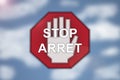 Bilingual Stop sign on blurred cloud background