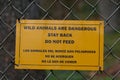 Bilingual warning sign near bear enclosure at zoo. Royalty Free Stock Photo