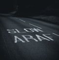 Bilingual "slow" road marking in Welsh and English.
