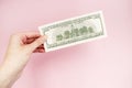 Bill in hand on a pink background. 100 dollars. Money Royalty Free Stock Photo