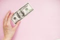 Bill in hand on a pink background. 100 dollars. Money Royalty Free Stock Photo