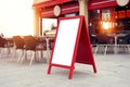 Billboard menu placeholder outside of cafe on the street near restaurant terrace seats, sunset light Royalty Free Stock Photo