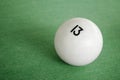 Billiard Ball number 13 on a pool table. A close-up image of an number thirteen ball on a pool table