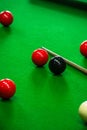 balls arranged around on a green billiards table next to cues Royalty Free Stock Photo