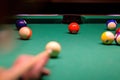 billiard balls in a green billiard table. Blurred hand with cue pointing at billiard ball at table Royalty Free Stock Photo