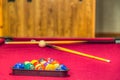 Billiard balls in a rack with cue sticks in the background Royalty Free Stock Photo