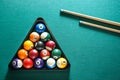 Billiard balls in triangle rack with cues on table Royalty Free Stock Photo